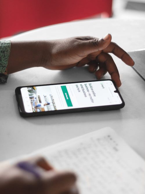 hand-over-a-cellphone-showing-shopify-app